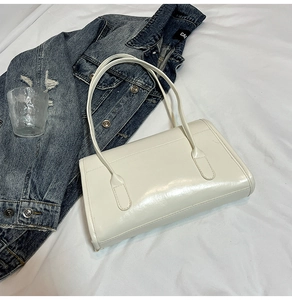Vue de dessus d'un grand sac cabas blanc brillant avec de longues bretelles sur denim