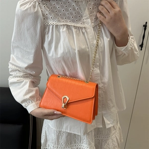 Orange faux crocodile skin shoulder bag with gold chain strap and heart-shaped lock