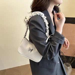 White woven baguette bag for women with silver butterfly buckle in a stylish 2025 design