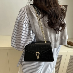 Elegant black crocodile texture shoulder bag with gold chain strap and horseshoe buckle