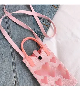 Detailed knit texture of pink heart pattern phone bag with wide shoulder strap