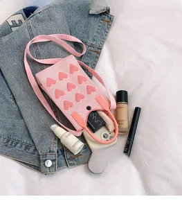 Pink knitted mesh phone bag interior showing space for cosmetics and essentials
