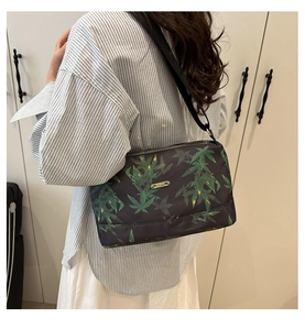 Detail view of fashion tote bag with green leaf pattern and adjustable black shoulder strap
