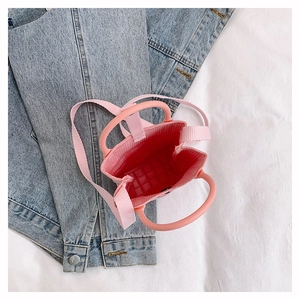Détail intérieur d'un mini sac cabas en maille rose avec sa bandoulière tissée réglable