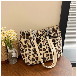 Detail of leopard print plush tote bag with cream leather strap and silver metal chain