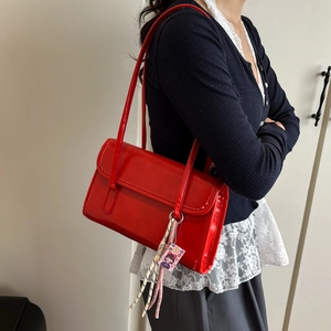 Minimalist red patent leather tote bag with glossy finish and cartoon charms