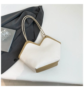 Detail of white crocodile pattern tote with V-cut design and brown leather straps