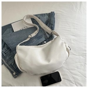 Detailed view of a white crescent moon shoulder bag with thick strap and minimalist design