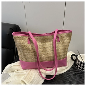 Detailed view of the woven straw texture and pink leather handles on this tote bag