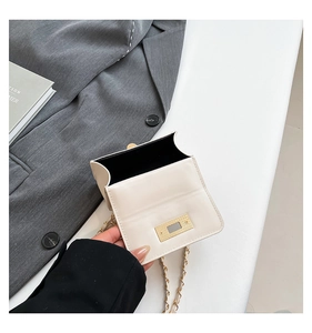 Close-up of cream crossbody bag interior with gold buckle and leather chain strap