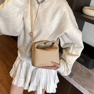 Elegant beige woven crossbody bag with gold metallic buckle and adjustable strap