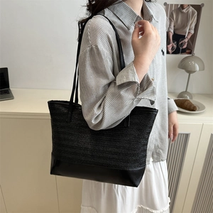 Chic black woven leather tote bag for women with minimalist shoulder straps in home setting