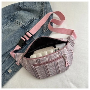 Detailed top view of striped canvas waist bag with adjustable strap on denim background