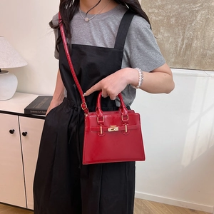Classic red structured handbag with gold lock and shoulder strap for elegant women