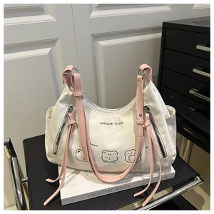 Detail of white canvas tote bag with pink straps and cute cartoon bear print on chair