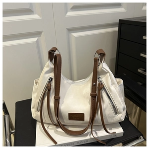 Detailed shot of a white hobo bag with brown straps and 'FASHION BAGS' leather patch