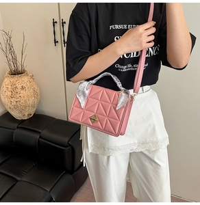 Detailed pink quilted crossbody bag with floral scarf handle and gold geometric twist lock