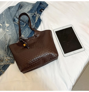 Top view of dark brown woven tote bag with shoulder strap and geometric texture detail