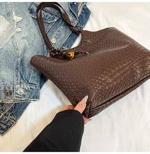 Detail of dark brown woven tote bag with checkerboard pattern and bell drawstring