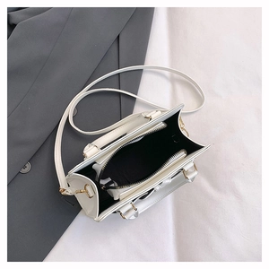 Vue détaillée de l'intérieur du sac à main blanc avec doublure noire et fermoirs dorés