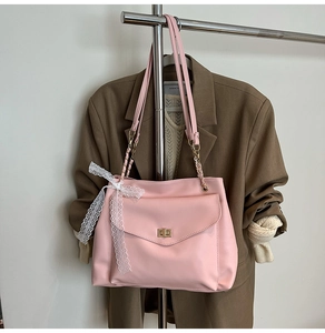 Sac fourre-tout rose avec chaîne dorée, détail de nœud en dentelle blanche et boucle