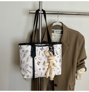 Détail du sac cabas blanc avec imprimés papillon noirs et charm lapin mignon