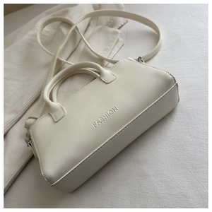 Detailed macro view of the cream leather handbag showing the silver FASHION letter logo