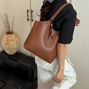 Minimalist brown woven tote bag with bell pendant for daily commute style
