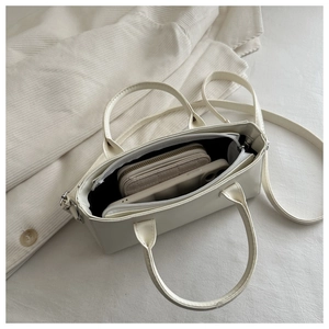 Top view of white leather handbag interior showing storage for phone and long wallet