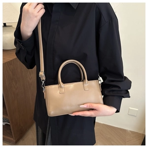 Primo piano della borsa in pelle kaki con rilievo FASHION e dettaglio del manico tondo