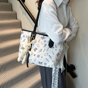 Grand sac fourre-tout blanc avec imprimés gribouillis noirs et pendentif lapin à l'épaule