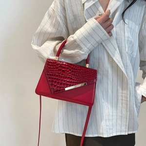 Elegant red leather handbag with crocodile pattern flap and gold metal bar detail