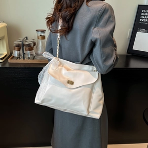 Borsa a tracolla bianca in ecopelle con fiocco in pizzo e catena dorata, design alla moda