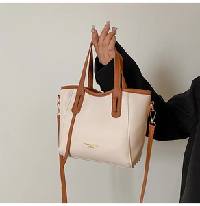 Close-up of contrast color leather tote bag with elegant handle and long shoulder strap
