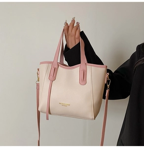 Detail showing contrast beige tote bag with pink handles and detachable shoulder strap
