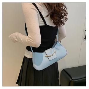 Detailed side view of a light blue underarm baguette bag with elegant gold hardware