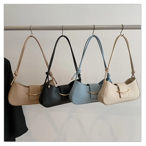 Row of minimalist half-moon shoulder bags in brown, black, blue, and white with gold accents