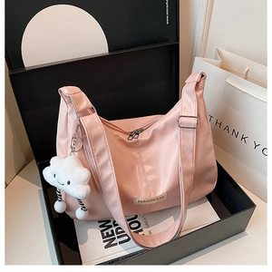 Close-up van lichtroze PU-lederen tote met een witte wolkhanger in een geschenkdoos