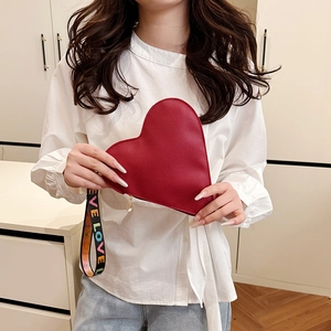 Red heart-shaped leather handbag with a colorful LOVE wrist strap shown by a model