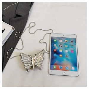 Détail du mini sac papillon argenté avec strass à côté d'un iPad pour la taille