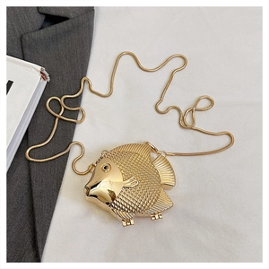 Vue détaillée de la pochette en métal doré en forme de poisson avec texture 3D et chaîne