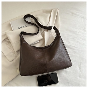 Deep brown leather tote bag detail with phone comparison showing large capacity