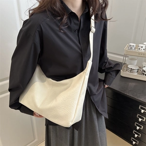 Minimalist large-capacity cream hobo tote bag with textured embossed finish on model
