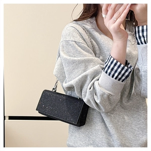 Détail d'un mini sac carré noir scintillant avec paillettes argentées et chaîne métal