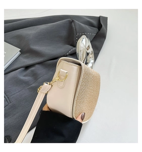 Detail of silver metallic handle and white faux leather on a golden sequined handbag