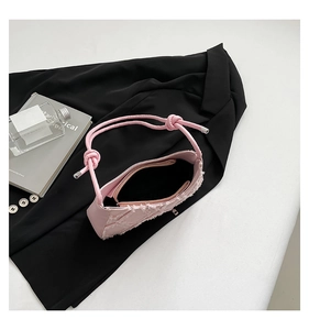 Top view of pink canvas shoulder bag with frayed edges and knotted rope strap