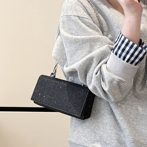 Petit sac bandoulière noir brillant avec chaîne argentée pour un style tendance