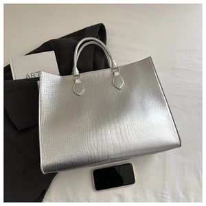 Detailed top view of a silver tote bag with crocodile embossing and metallic texture