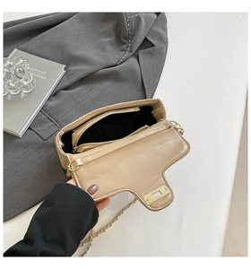 Vue détaillée de l'intérieur du sac beige avec plusieurs compartiments et fermoir doré