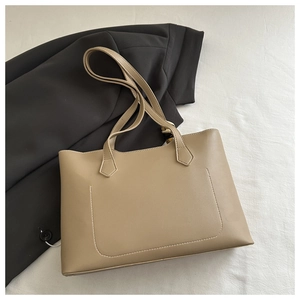 Vue détaillée d'un sac cabas en cuir kaki avec poche décorative avant et poignées plates